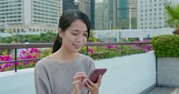 Woman check on smart phone in city