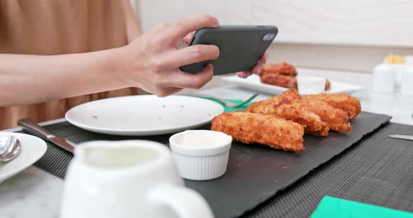 Woman Taking Photo on Her Fried Chicken Wing