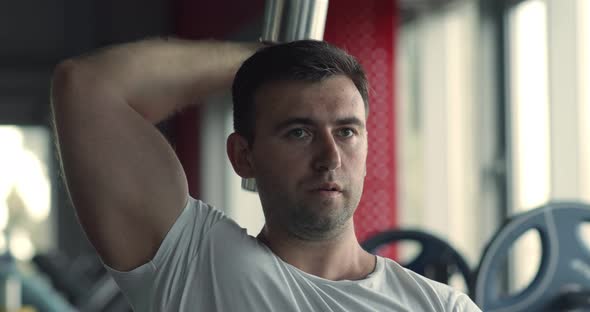 Close Up Portrait of Bodybuilder Practicing Triceps Workout , Exercising with Dumbbell at Gym