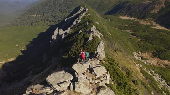 Aerial View of Hiker Couple of Tourists with Backpack on Top of a Mountain