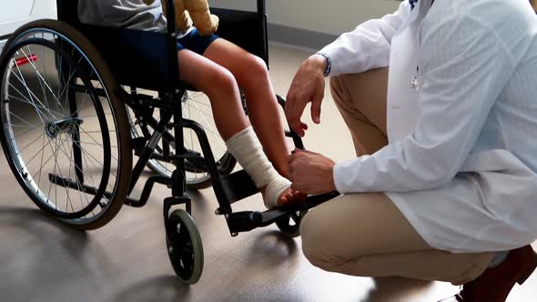 Male doctor interacting with child patient in ward