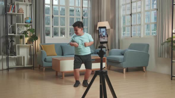 Asian Little Boy Dancing While Shooting Video Content For Social Networks With A Smartphone Camera