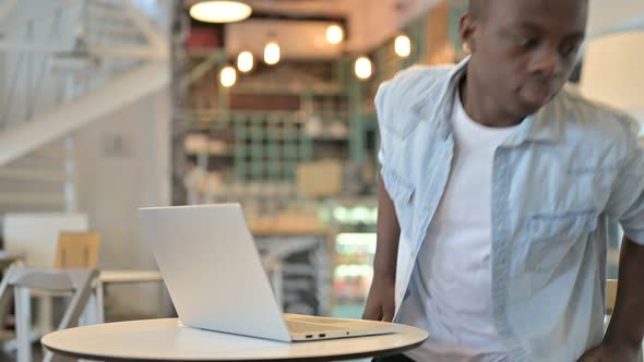 African Man Leaving Work and going Away in Cafe