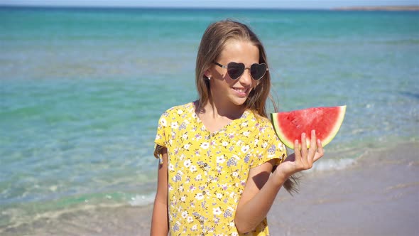 Happy Girl Having Fun on the Beach and Eating Watermelon