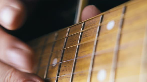 Person Beats Metal Nylon Strings of Brown Acoustic Guitar