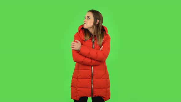 Lovely Girl in a Red Down Jacket Is Very Offended and Looking Away. Green Screen