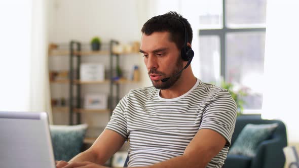 Man with Headset and Laptop Working at Home