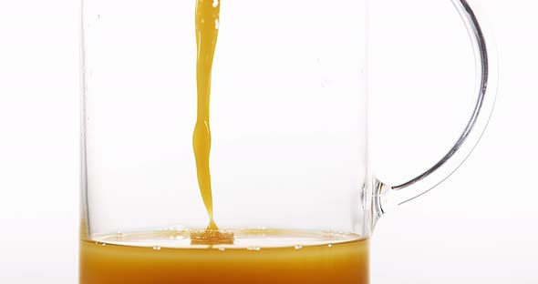 Orange Juice being poured into Glass against White Background, Slow Motion 4K