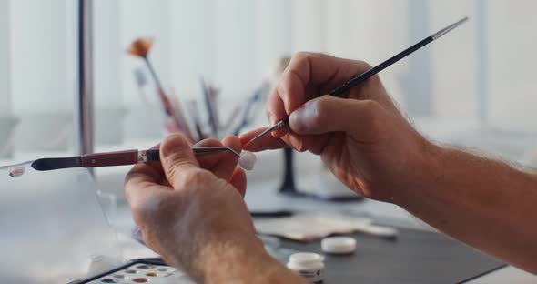 Closeup of Painting a Ceramic Dental Crown with a Thin Brush By Hand