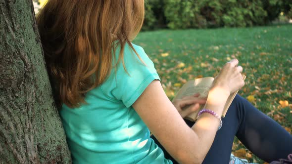 Girl With The Bike Resting And Reading At The Park