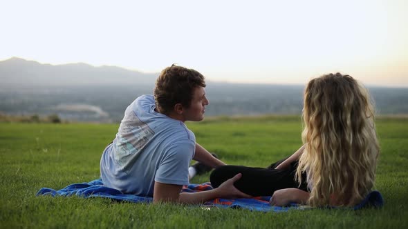 Slow Motion shot of cute couple laying on a blanket and having a picnic on the grass.