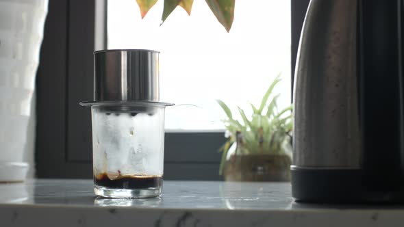 CloseUp Of A Transparent Glass Standing on The Table Dripping Coffee Drop By Drop