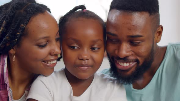 Close Up Portrait of Joyful African American Parents with Cute Preteen Daughter