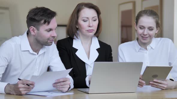 Business People Discussing Project On Laptop