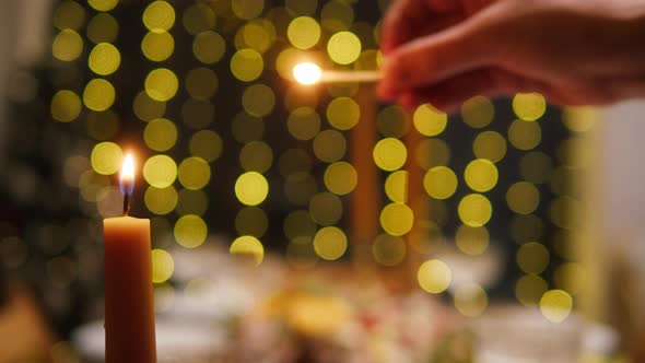 Woman Lighting Candles on Dining Table Closeup