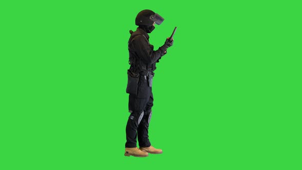 Police Tactical Officer Checking His Hand Gun and Folding Hands on a Green Screen Chroma Key