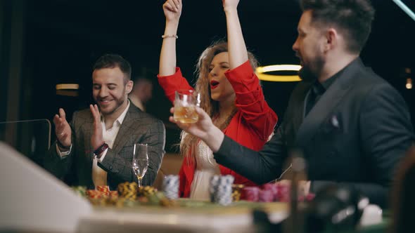 Two Bearded Men and Young Woman are Winning and Rejoice in Victory at the Casino