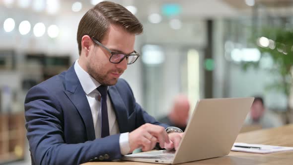 Businessman with Laptop Smiling at the Camera 