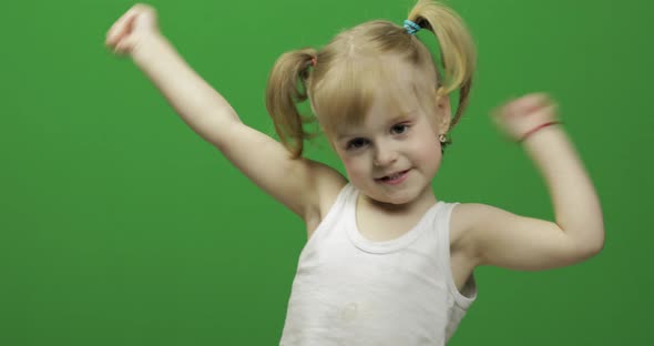 Happy Little Girl in White T-shirt. Cute Blonde Child. Dancing and Make Faces