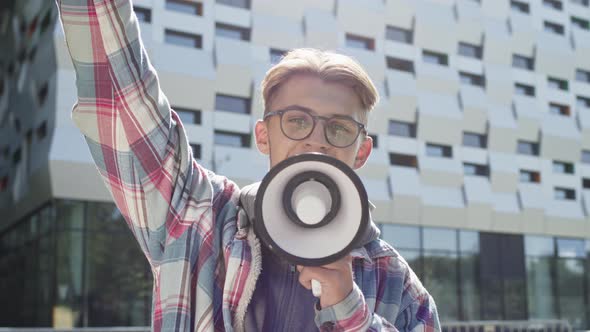 Young Guy Speaks Into Loudspeaker On The Street.