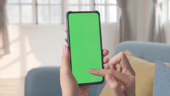 Hand Female Using Smartphone With Green Screen In Living Room