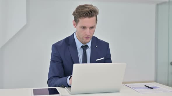 Ambitious Businessman Celebrating Success on Laptop