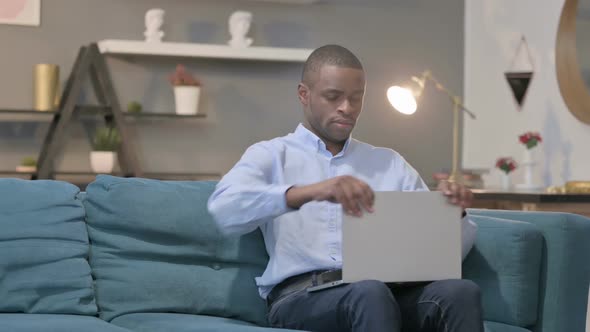 African Man Closing Laptop Standing Up Going Away