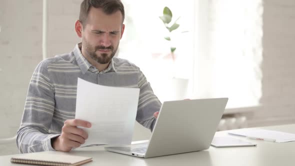 Tense Adult Young Man Reading Office Documents