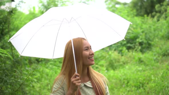 Woman walking hand holding white umbrella under rain