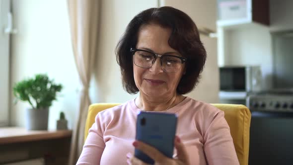 Elderly Woman Using Device and Enjoying Lifestyle at Home Room During Pandemic