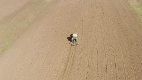 Drone shot following tractor preparing field for sowing Near Mont-Pèlerin, Vaud, Switzerland