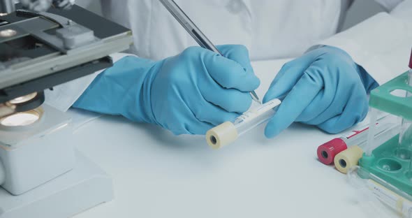 Laboratory Assistant Signs Pen Test Tubes To Collect Analysis and Further Research