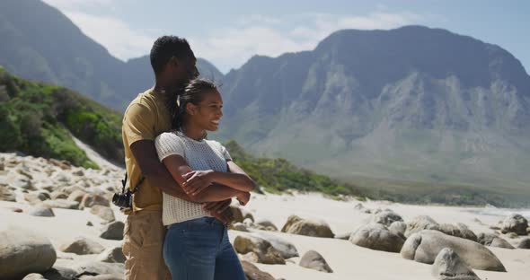 African american couple embracing each other while hiking in the mountains