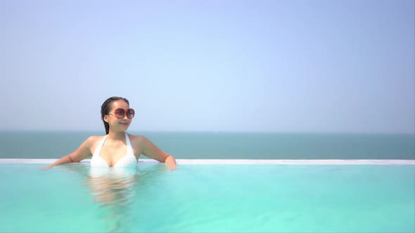 Young asian woman enjoy around outdoor swimming pool for leisure