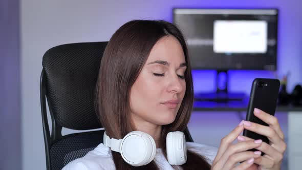 Woman Looking at Smart Phone Reading News Bored and Sleepy at Home