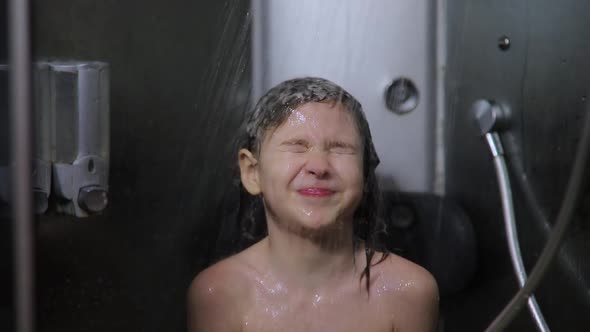 Child Washes His Head Under Stream of Warm Water