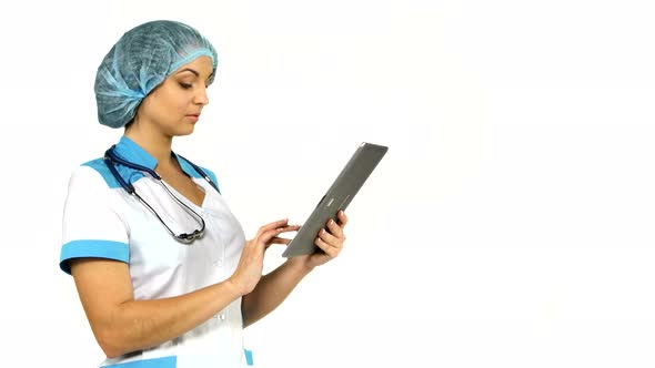 Young Female Medical Nurse Using Tablet Computer on White Background.