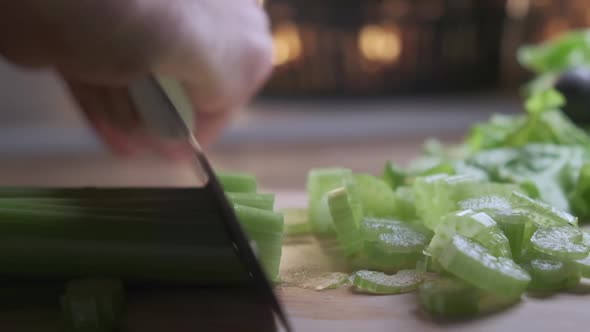 Cutting Celery Using Kitchen Knife on Wooden Board Fresh Healthy Celery for Eating and Cooking