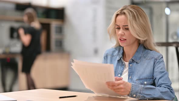 Young Casual Woman Reacting To Loss on Documents at Work 