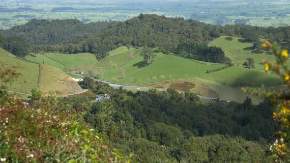 View From Kaimai Range Of Vehicles Passing By At The State Highway 29 In New Zealand With Lush Green