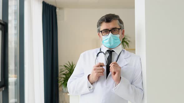 Portrait of a Senior Doctor in White Suit and Protective Mask