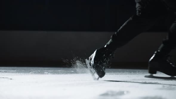 Male Figure Skater is Training or Performing on Ice Rink Closeup View of Feet Shod Skates Gliding