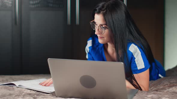 Freelancer Girl Work at Home Using Laptop and Paper Document