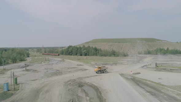 Heavy Truck Belaz Rides on the Background of Green Rock Dumps Slow Motion