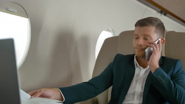 Mature Business Man Talking By Mobile Phone in Aircraft
