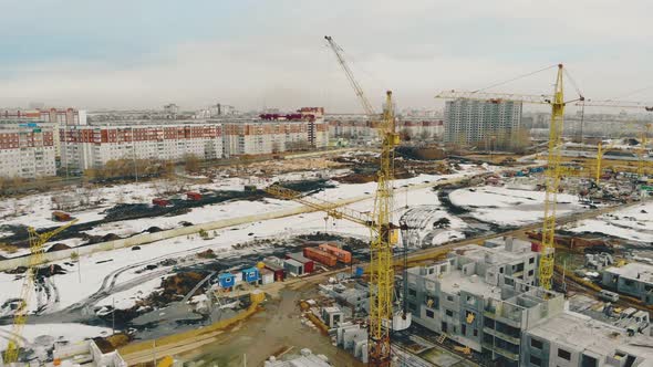 Yellow Building Cranes Located in Row on Construction Site