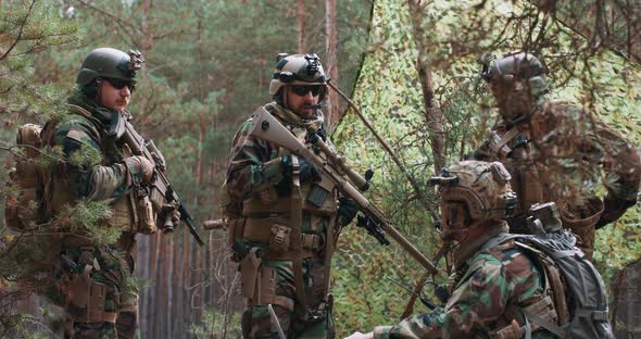 Bearded Soldiers in Woodland Uniforms with Helmets on Their Heads and with Rifles in Their Hands