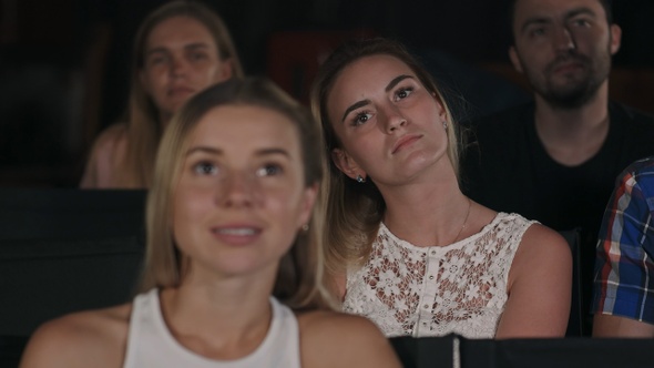 Group of friends watching a movie at the cinema theater