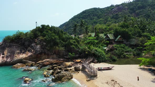 Fishing boat and a wooden deck on the Haad Than Sadet Beach, Koh Phangan, Thailand during the low ti