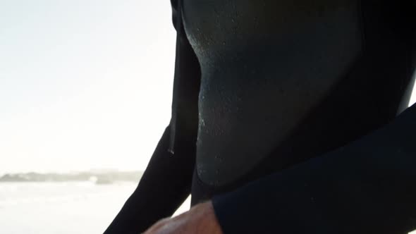 Male surfer standing in the beach